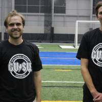 Students wearing championship shirts from a spikeball tournament on Monday
